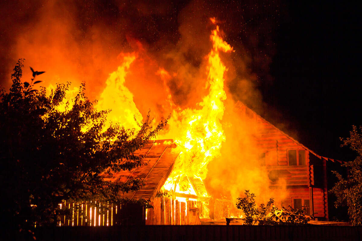 Burning wooden house at night